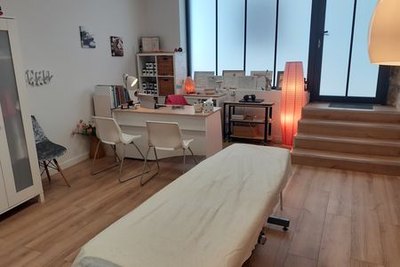 La salle de soin, table de consultation et bureau, vue depuis l'entrée